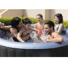 Familj som kopplar av i en uppblåsbar bubbelpool utomhus.