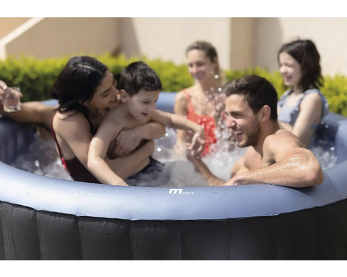 Familj som kopplar av i en uppblåsbar bubbelpool utomhus.