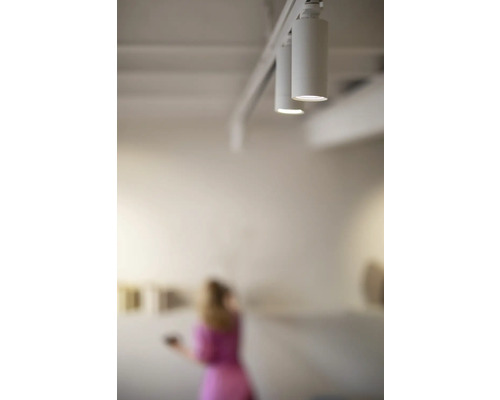 Skena med flera spotlights i taket i ett ljust rum.