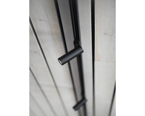 Svart taklampa med skenor på ett trätak