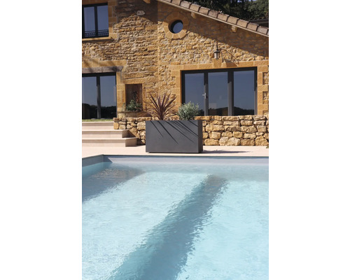 Stenhus med pool och planterad blomlåda i trädgården.