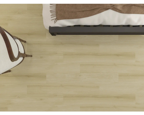 Vy över ett ljust trägolv med säng och stol.