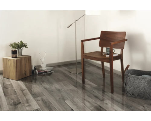 Vardagsrum med trägolv, trästol, golvlampa och sidobord