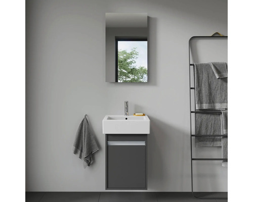 Badrum med handfat, spegelskåp och handdukshållare