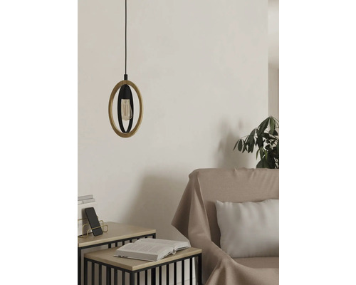 Pendellampa med trä- och metallelement ovanför ett sidobord