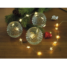 Dekoration med stjärneljusslinga, värmeljus och julgranskvist på träbord