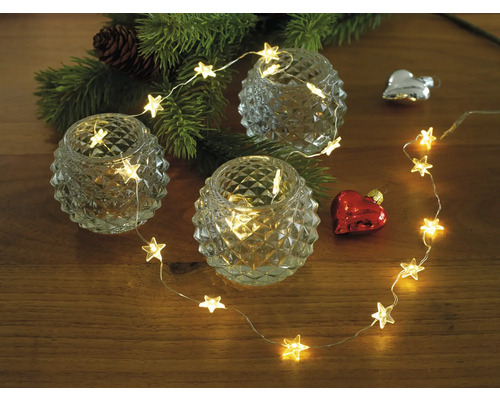 Dekoration med stjärneljusslinga, värmeljus och julgranskvist på träbord