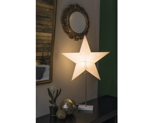 Dekorativt arrangemang med stjärnlampa, speglar och ornament på ett bord