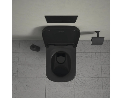 Svart toalett med cistern, toalettborste och pappershållare