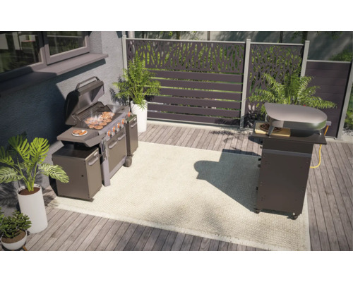 Uteplats med grill, pizzaugn och dekorativt insynsskydd