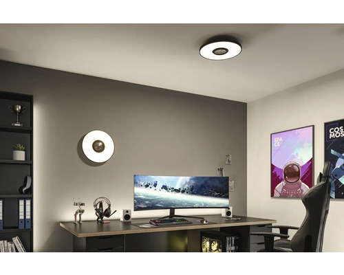 Modernt arbetsrum med skrivbord, dator och runda tak- och vägglampor.
