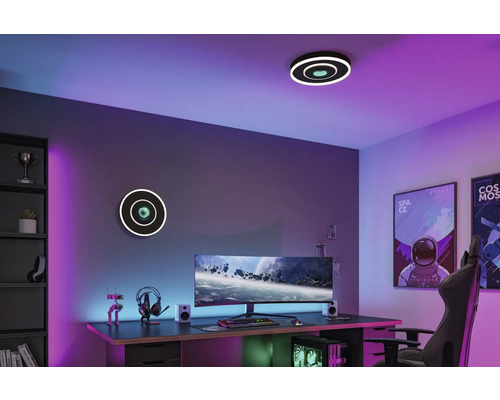 Modernt tonårsrum med cirkelformade tak- och vägglampor, utrustat med skrivbord, dator och speltillbehör.