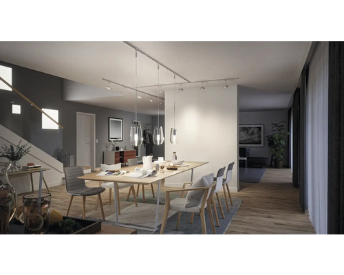 Ljus matsal med träbord, stolar och skenspots för modern belysning.