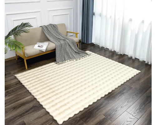 Vardagsrum med soffa och mönstrad, rektangulär matta.