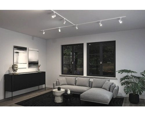 Vardagsrum med flexibel skenmonterad belysning, soffa och dekoration