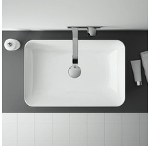 Översikt över ett badrum med handfat, armatur, tvålbehållare, handduk och kakel