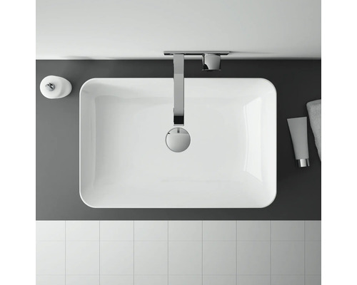 Översikt över ett badrum med handfat, armatur, tvålbehållare, handduk och kakel