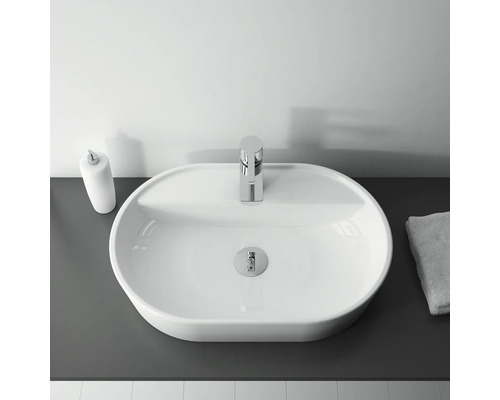 Ovanifrån av ett handfat med blandare, tvålpump och handduk