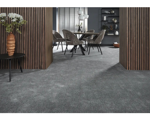 Interiör med grå heltäckningsmatta, matbord med stolar, träpanel på väggarna och dekorativa element.