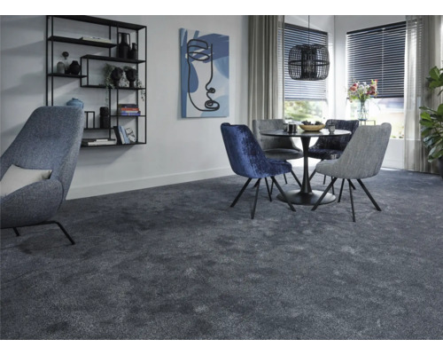 Modernt vardagsrum med heltäckningsmatta, matbord och stolar samt hylla