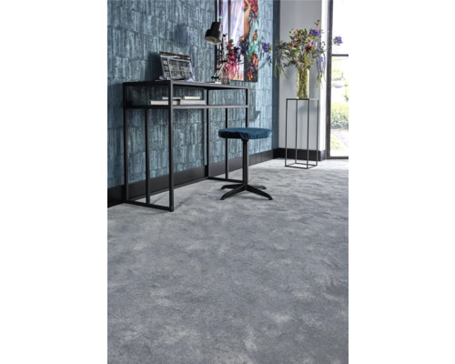 Vy från ett arbetsrum med en grå heltäckningsmatta, ett skrivbord med kontorsstol och dekorationer.