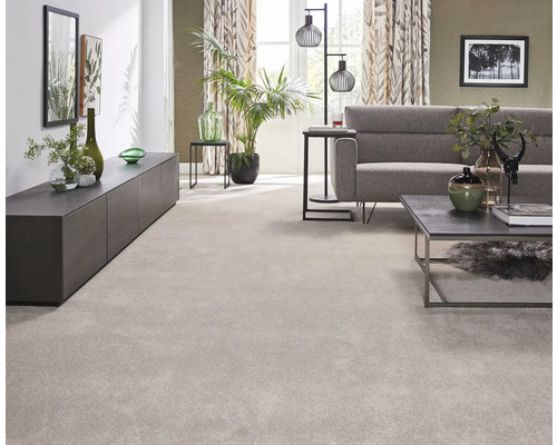 Vardagsrum med ljus matta, soffa, bord och växter