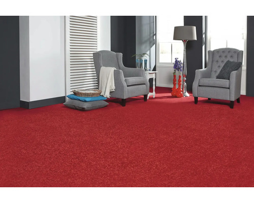 Vardagsrum med röd matta, två grå fåtöljer och dekorativa element