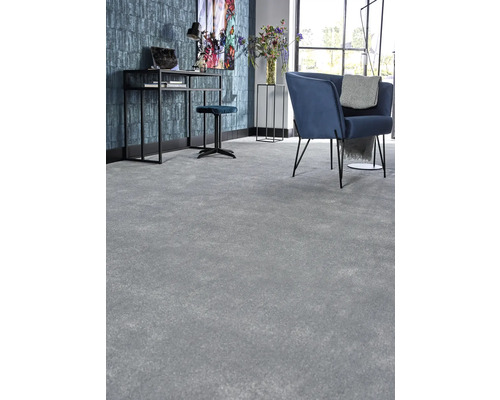 Vardagsrum med heltäckningsmatta, skrivbord och fåtölj