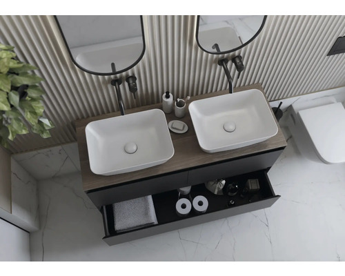 Badrum med dubbla handfat, underskåp med utdragslåda och toalett.