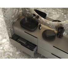 Modernt badrum med tvättställ, svart tvättställsskål, kran och spegel