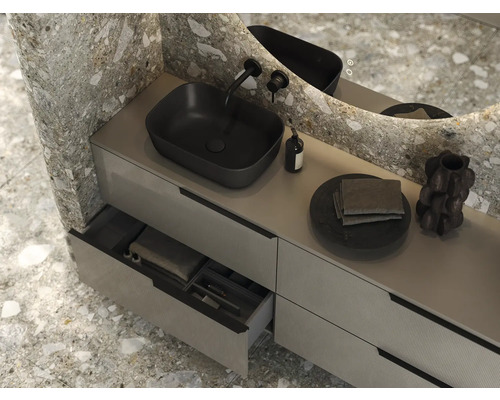 Modernt badrum med tvättställ, svart tvättställsskål, kran och spegel