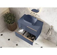 Modernt badrum med blått underskåp, tvättställsskål och öppen låda för förvaring av badrumsartiklar.