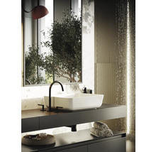 Modernt badrum med rektangulärt handfat, blandare, handdukar och dekorativa element.