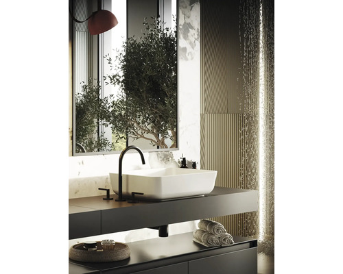 Modernt badrum med rektangulärt handfat, blandare, handdukar och dekorativa element.