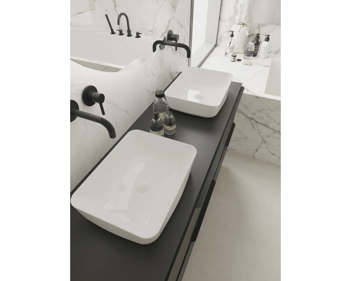 Ljust badrum med dubbla handfat på mörk underskåp, armaturer och badkar