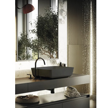 Modernt badrum med svart tvättställ, armatur och handdukar på hyllan