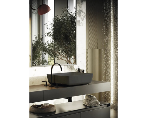 Modernt badrum med svart tvättställ, armatur och handdukar på hyllan