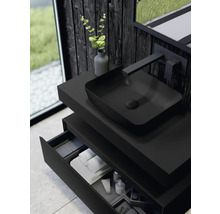 Modernt badrum med svart tvättställ, tvättställsskål, armatur och öppen låda