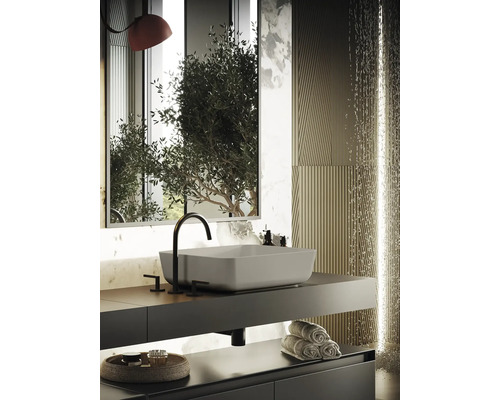 Modernt badrum med handfat, kran, spegel och handdukar