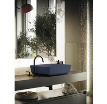 Modernt badrum med blått tvättställ, svart armatur och stilren inredning