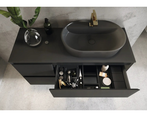 Badrum med grått tvättställsskåp, tvättställsskål och öppen låda med badrumsartiklar