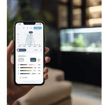 En smarttelefon visar en app för att styra akvariumbelysning med diagram och inställningar.
