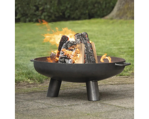 Eldstad av stål med brinnande ved i trädgården