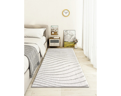 Sovrum med säng, sängbord och randig matta