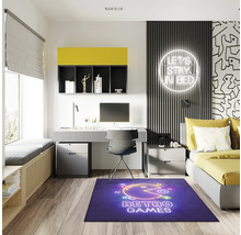 Modernt ungdomsrum med skrivbord, säng och blå matta med retrospelsmotiv.