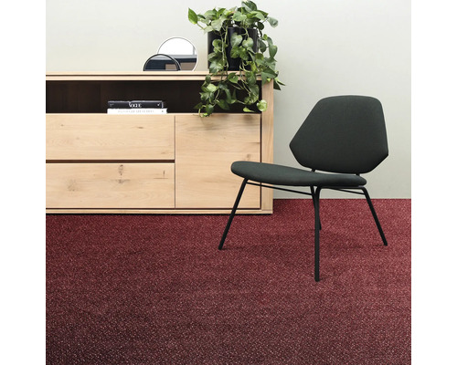 Rumsöversikt med byrå, krukväxt, stol och röd matta