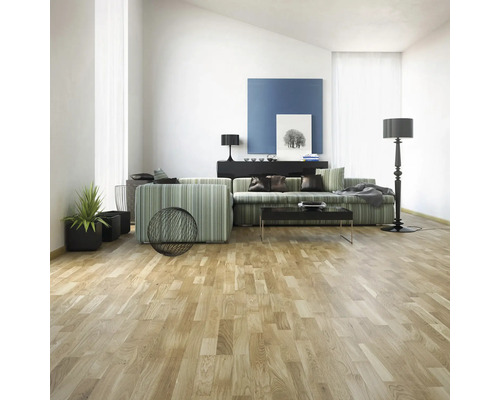 Vardagsrum med soffa, bord, golvlampa och trägolv