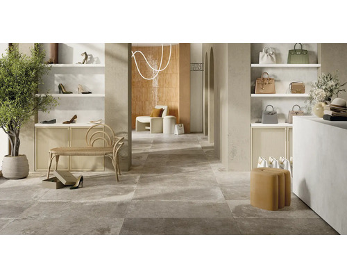 Interiör i en klädaffär med hyllor, sittplatser och grå plattor