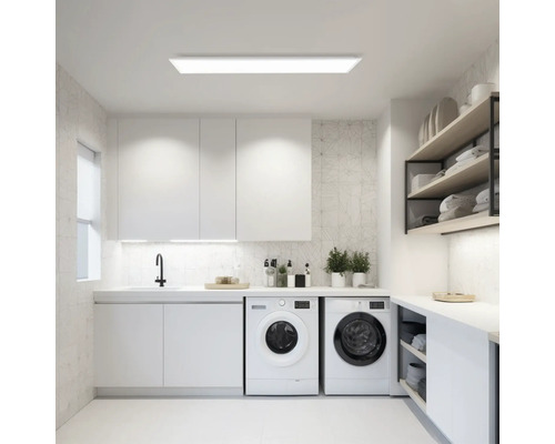 Ljust tvättrum med tvättmaskiner, diskho och hyllor