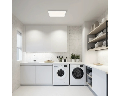 Ljust tvättrum med tvättmaskiner, hyllor och taklampa